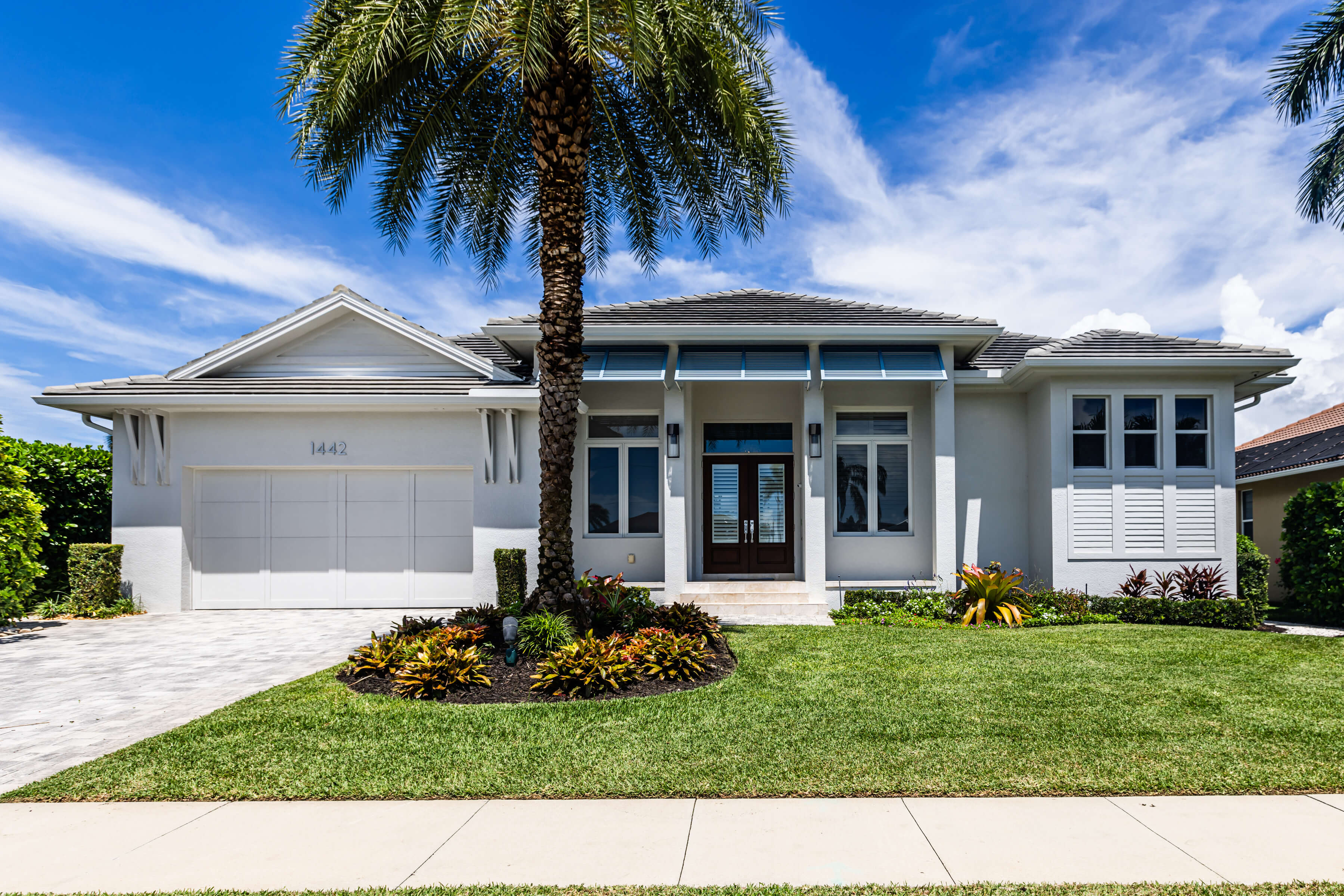 Modern new construction home in Florida with palm tree landscaping, representing tailored homeowners insurance coverage for newly built properties.